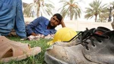 Construction workers rest during the midday break at Sharjah's corniche.