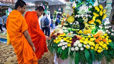 Two Buddhist monks look at an elaborate display of carved fruits and vegetables during a fruit and vegetable carving competition in Bangkok. Robert Schmidt / AFP