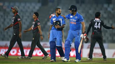 India’s Shikhar Dhawan, foreground left, and Yuvraj Singh, foreground right, walk out from the field after winning the Asia Cup Twenty20 international cricket match against United Arab Emirates in Dhaka, Bangladesh, Thursday, March 3, 2016. (AP Photo/A.M. Ahad)