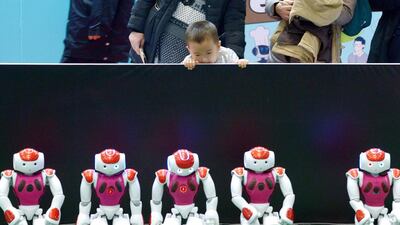 A boy looks at a display of robots during the World Robot Conference. Wang Zhao / AFP