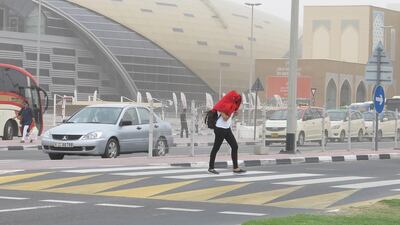 Dubai, United Arab Emirates - March 20, 2017. Pedestrian protects herself against the windy situation, at the Ibn Batuta area. ( Jeffrey E Biteng / The National ) *** Local Caption *** JB200317-Weather04.jpg