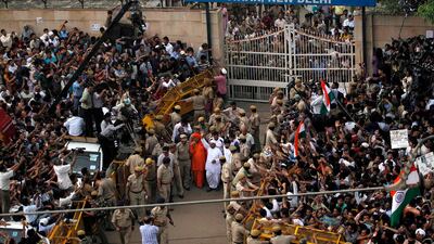 August 19, 2011: Anti-corruption crusader Anna Hazare, center, waves to the crowd after emerging from the gates of Tihar prison in New Delhi, India. Nearly 2,000 men, women and schoolchildren had gathered outside Tihar Jail on Friday morning to catch sigh???