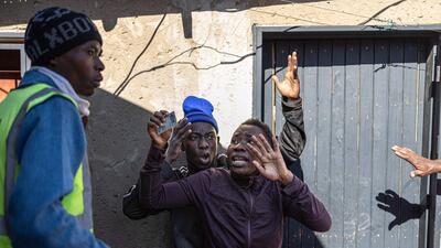 A South African resident holds up his ID card during an anti-migrant protest in Alexandra, near Johannesburg. AFP