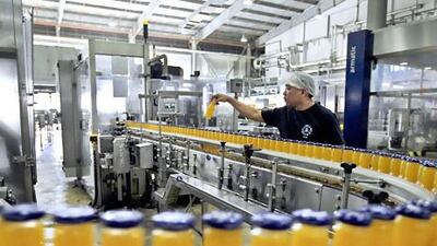 A worker monitors a production line at Aujan Industries' juice factory in Dubai. The company produces Vimto, Rani and Barbican. Jumana El Heloueh / Reuters