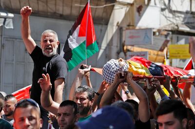 Relatives mourn the death of 15-year-old Islam Wael Bernat during his funeral procession in in the city of Al Bireh, northeast of Ramallah on May 19, 2021. The health ministry said four Palestinians were killed in the occupied West Bank, as the Israeli army said its troops were targeted by gunfire there. AFP