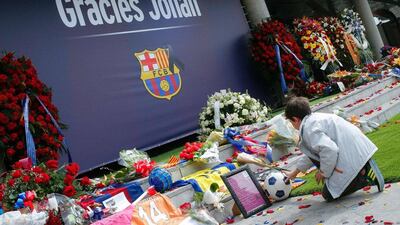 A FC Barcelona fan puts ball on the ground as he pays tribute to late Dutch football star Johan Cruyff in a special condolence area set up at Camp Nou stadium, in Barcelona on March 27, 2016. Cruyff, one of the greatest footballers of all time who dazzled with his artistry, died on March 24, 2016 at the age of 68 after losing a battle with lung cancer, prompting an avalanche of tributes from around the sports world. / AFP / PAU BARRENA