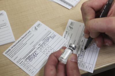 A healthcare worker fills out a Covid-19 vaccination record card during an immunisation event in New York City. Bloomberg