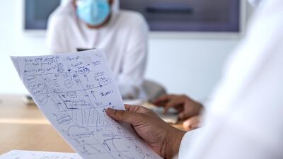 The group go over hand-sketched designs in Abu Dhabi. Victor Besa / The National