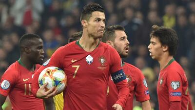 Cristiano Ronaldo holds the ball during the Euro 2020 football qualification match between Ukraine and Portugal at the NSK Olimpiyskyi stadium in Kiev on October 14, 2019. AFP