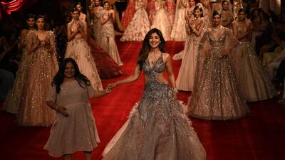 Bollywood actress Shilpa Shetty Kundra (C) walks with Indian fashion designer Dolly J during the FDCI India Couture Week in New Delhi on July 28, 2022. (Photo by Money SHARMA / AFP) / IMAGE RESTRICTED TO EDITORIAL USE - STRICTLY NO COMMERCIAL USE -