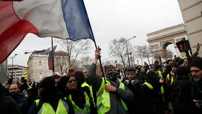 Demonstrators wearing yellow vests march down the Champs Elysees holding the French tricolor in Paris. AP Photo