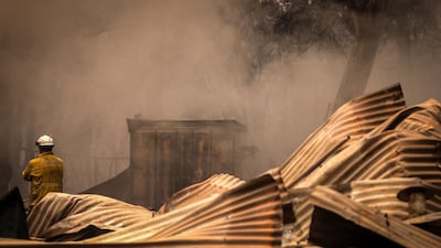 Firemen inspect a house recently destroyed by bushfires on the outskirts of the town of Bargo. Getty Images
