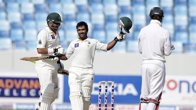Pakistan’s Asad Shafiq, right, is congratulated by his captain Misbah-ul-Haq on his reaching the century milestone. Hassan Ammar / AP Photo