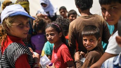 Displaced Syrian children who fled the countryside surrounding ISIL's Raqqa stronghold wait for food to be distributed at a temporary camp in the village of Ain Issa on July 11, 2017. Bulent Kilic / AFP