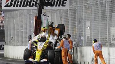 Track marshals recover Nelson Piquet's crashed Renault F1 car during the Singapore Grand Prix on September 28, 2008. Piquet has alleged that his former Renault team ordered him to crash in that race to bring out the safety car and help Spanish teammate Fernando Alonso take first place.