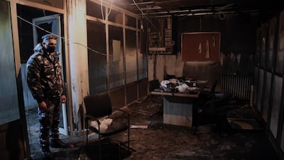 A policeman looks at the damage inside a burned-out office on Tripoli Saraya Square where is a police station and the Sunni Sharia Court were set on fire in protests against the economic situation. EPA