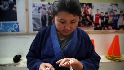 Jiu Jitsu club member Liqa Esazada looks at her injury practice during a training session in Kabul. AP