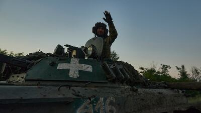 A Ukrainian soldier waves from atop an APC at the front line near Bakhmut in Donetsk region. AP