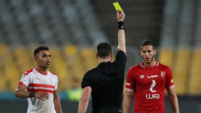 Al Ahly's Ramadan Sobhi is shown a yellow card by referee Istavan Kovacs. Reuters
