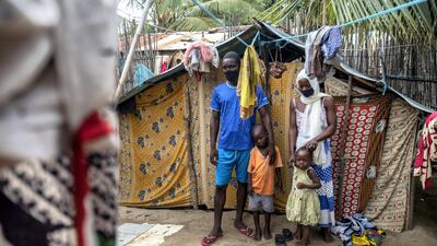 Ali Issa (L) and his wife Asha Ambas, who moved with their two children to the Paquitequete neighborhood in Pemba City after armed insurgents attacked the Macomia district, pose for pictures in Paquitequete. AFP