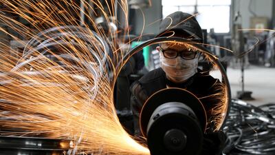 A worker polishes a bicycle steel rim at a factory manufacturing sports equipment in Hangzhou, Zhejiang province, China. Reuters