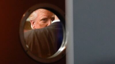 Republican presidential nominee Donald Trump is seen through the window of a door before speaking at a campaign event at a restaurant in Las Vegas. AP Photo