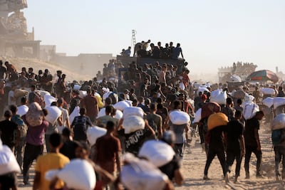 Palestinians collect aid in Beit Lahia, northern Gaza. Reuters