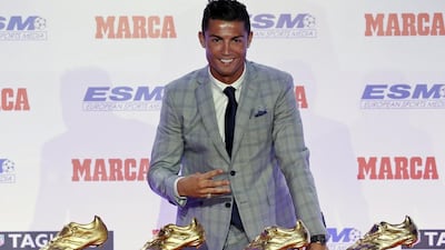 Real Madrid striker Cristiano Ronaldo poses in front of his four Golden Boot trophies during a ceremony in Madrid, Spain, October 13, 2015. Andrea Comas / Reuters