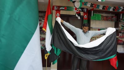 Bisharat Ali at Adam Gallery in Abu Dhabi folds up a massive 10 metre UAE flag ahead of the Flag Day. Delores Johnson / The National