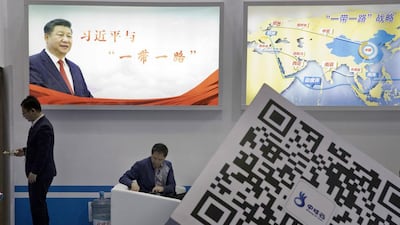 Visitors at a technology conference In Beijing wait near illuminated boards highlighting Chinese President Xi Jinping's Belt and Road Initiative. AP
