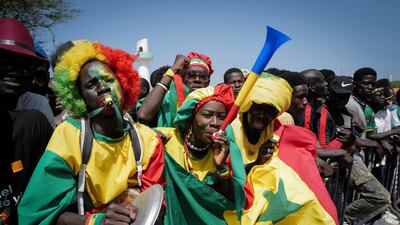 Senegalese fans celebrate as they await the return of their national football team in Dakar on Monday. AP