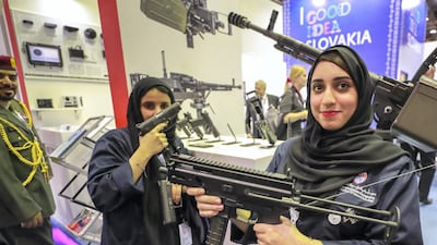 Idex 2019 visitors pose with firearms at the exhibition. Victor Besa/The National