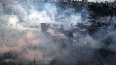 Protesters run to avoid tear gas during clashes at Istanbul's Taksim Square.