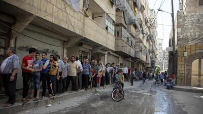 Syrians queue up to buy bread in a rebel held neighbourhood in the northern city of Aleppo on July 12, 2016. Karam Al Masri / AFP