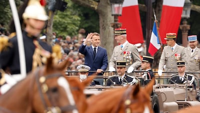 French President Emmanuel Macron with French Chief of Staff Gen Francois Lecointre in the command car as they review troops during the Bastille Day parade.