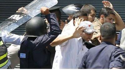 Jordanian police beat a protester during a demonstration in Amman.