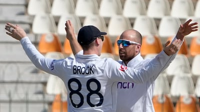 England's Jack Leach, right, celebrates with teammate Harry Brook after taking the wicket of Pakistan's Abdullah Shafique. AP