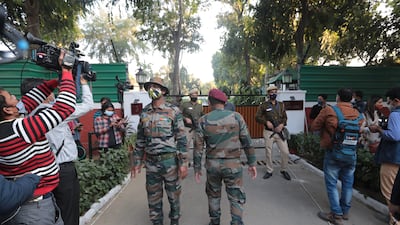 People gather outside the residence of Chief of Defence Staff Gen Bipin Rawat in New Delhi. A helicopter carrying him, his wife and several top military officials crashed in the hills of south India, killing 13 people on board, including the top official, the country's air force said. EPA
