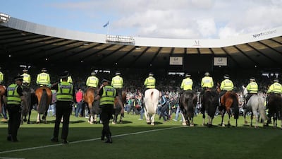 Police move Hibernian fans off the pitch as they celebrate at the end of the match after winning the Scottish Cup Final. Reuters / Russell Cheyne