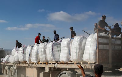 Palestinian clan members hold melee weapons to secure an aid lorry in Beit Lahia, in the northern Gaza Strip, Reuters