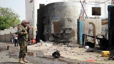 A Yemeni soldier inspects the site of a car bomb attack that targeted a police station. EPA
