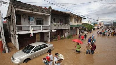 Residents wade through floodwaters brought about by typhoon Mirinae on Saturday, October 31, 2009.