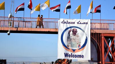 Iraqi and Vatican flags and a picture of Pope Francis in Qaraqosh, about 30 kilometres east of Mosul in northern Iraq. EPA