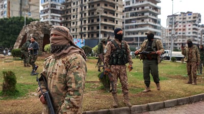 Fighters affiliated with Syria's new government stand guard in Latakia in late December, after protests started by an online video showing an attack on an Alawite shrine. AFP