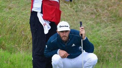 Dustin Johnson of the United States is sheltered from the rain by his caddie Austin Johnson as he prepares to putt on the 10th green during the second round on day two of the 145th Open Championship at Royal Troon on July 15, 2016 in Troon, Scotland. (Photo by Stuart Franklin/Getty Images)