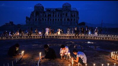 Afghan youths light candles in front of the destroyed palace of Darul Aman to mark the killing of 5000 civilians by the communist regime during the Russian occupation, in Kabul, Afghanistan. Massoud Hossaini / AFP