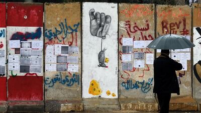 epa08205408 A man looks at university degrees placed by Lebanese unemployed graduates on the concrete wall which was set up by Lebanese police to block a road leading to the Government palace in downtown Beirut, Lebanon, 09 February 2020. According to media reports, the number of unemployed Lebanese has now reached around 200,000 since October, 60,000 of whom lost their jobs since the end of November 2019. Unemployment has increased dramatically in the past few months with a deteriorating economic situation, and not only among the youth. EPA/WAEL HAMZEH
