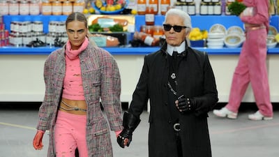 Lagerfeld with model Cara Delevingne, one of his many muses, at Paris Fashion Week in 2014. Getty Images