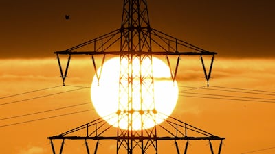 The sun rises behind a pylon and power lines in Frankfurt, Germany, as the world grapples with an energy crisis. AFP