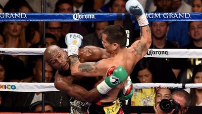 Floyd Mayweather and Marcos Maidana get tangled up during their title fight on Saturday. Ethan Miller / Getty Images / AFP